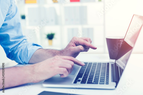 Close up of businessman typing at laptop