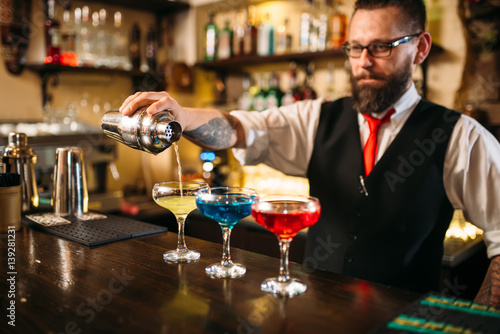 Barman making alcohol cocktails in nightclub