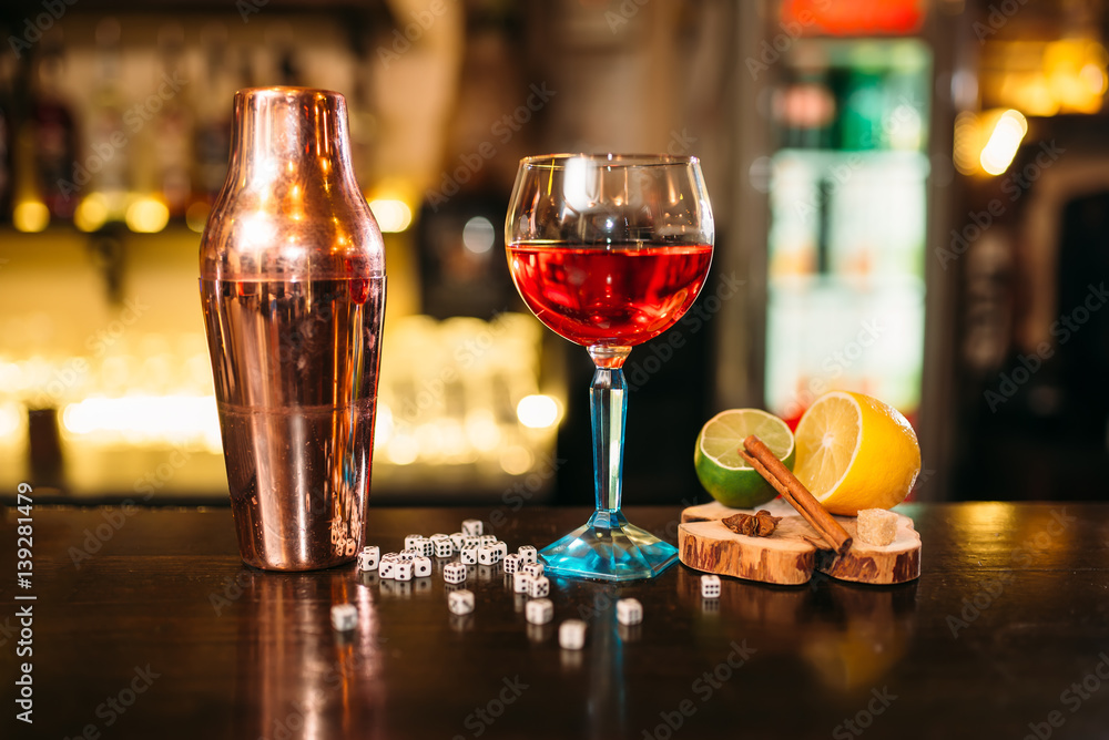 Naklejka premium Alcoholic cocktail, shaker and dice on bar counter
