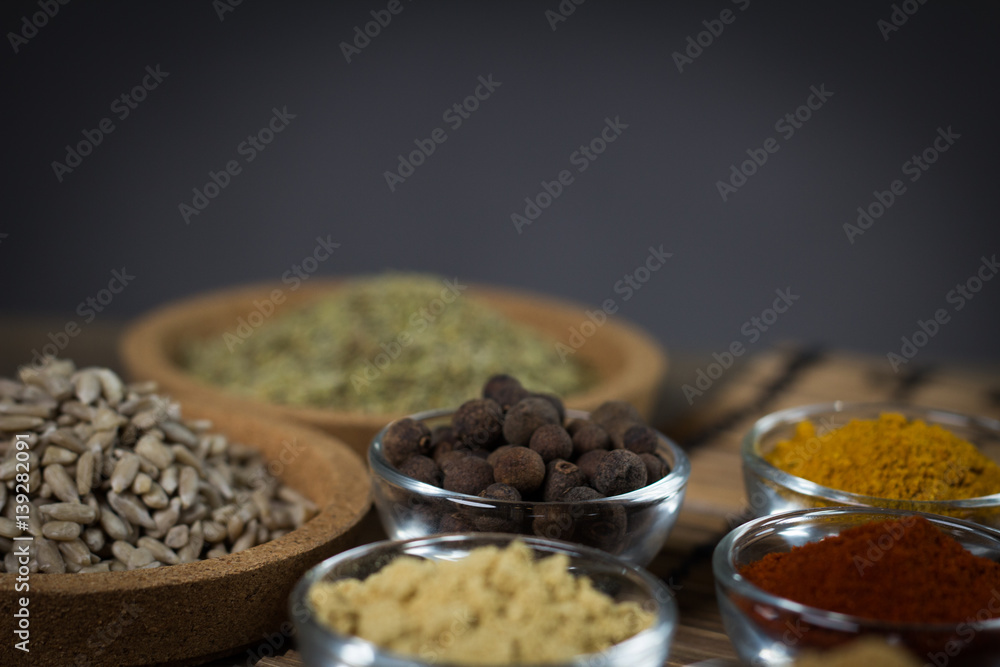 Various spices in bowls with fresh seasoning on rustic wooden background, closeup Various spices in bowls with fresh seasoning on rustic wooden background, closeup