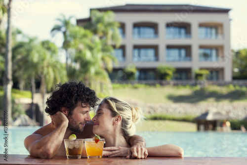 Couple relaxing together in resort pool photo