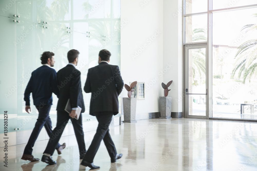 Business people walking together in office corridor Business people walking together in office corridor