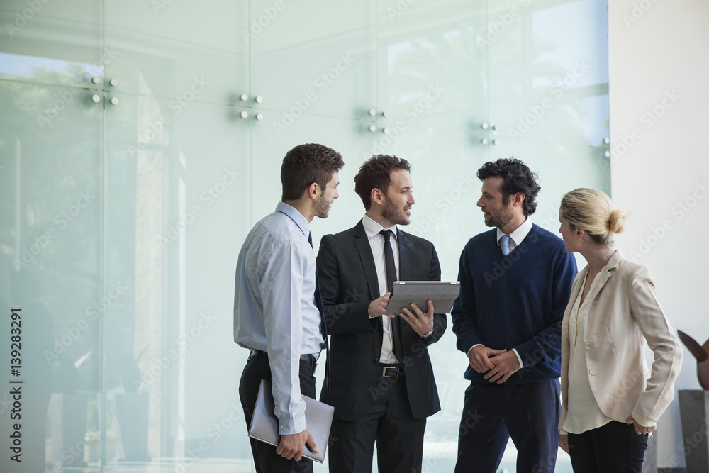 Business people discussing with each other in the office corridor Business people discussing with each other in the office corridor