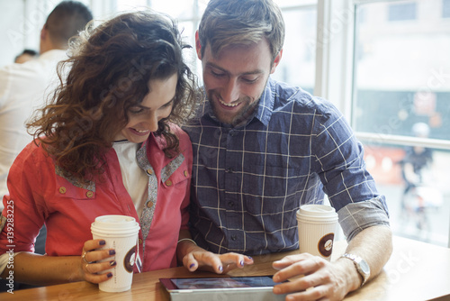 Couple using digital tablet in coffee shop