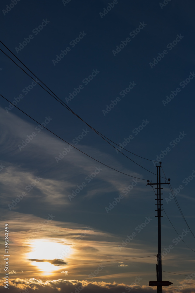 High voltage power lines on colorful sky background at sunset.