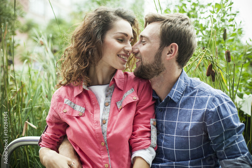 Young couple nuzzling each other in the outdoors