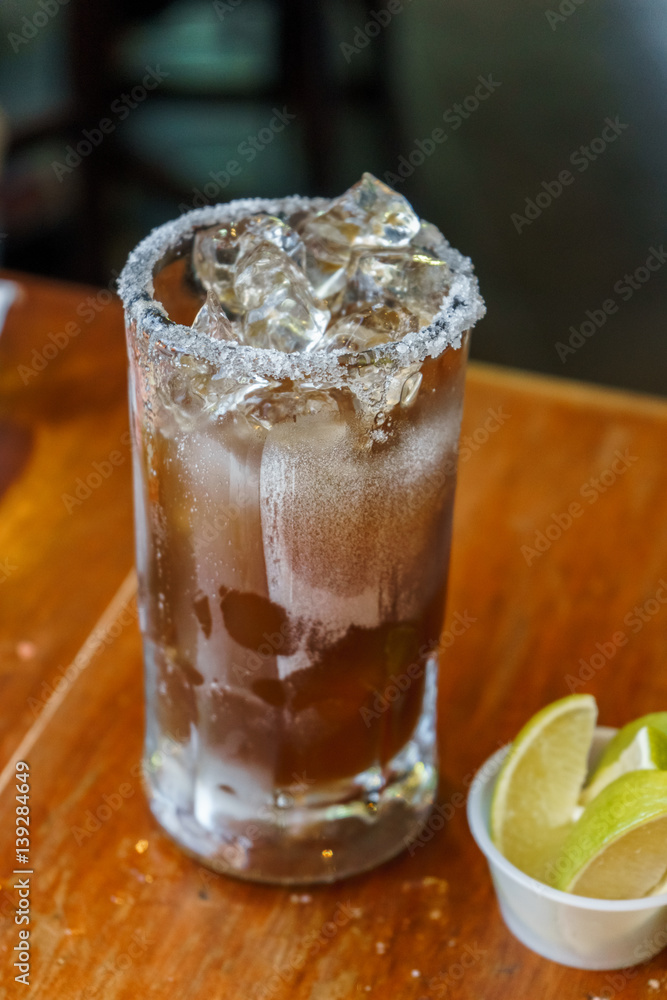 Natural Michelada with lemon and beer in a frozen glass jar. Natural Michelada with lemon and beer in a frozen glass jar.