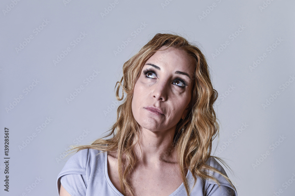 blond attractive woman on her thirties sad and depressed looking desperate in sorrow