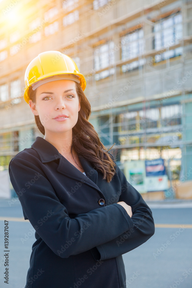 Fototapeta Portrait of Young Attractive Professional Female Contractor Wearing Hard Hat at Construction Site.