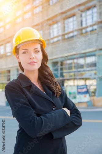 Portrait of Young Attractive Professional Female Contractor Wearing Hard Hat at Construction Site.