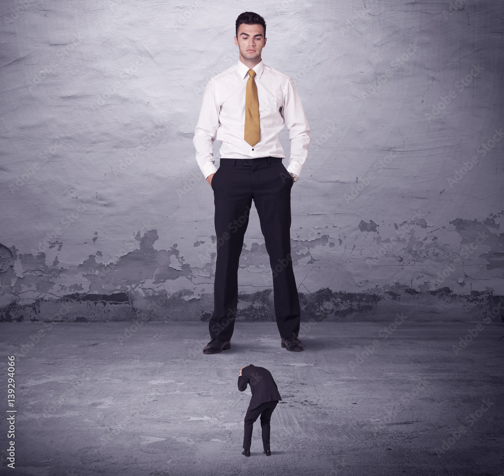 Fototapeta premium Angry big manager looking at small business man