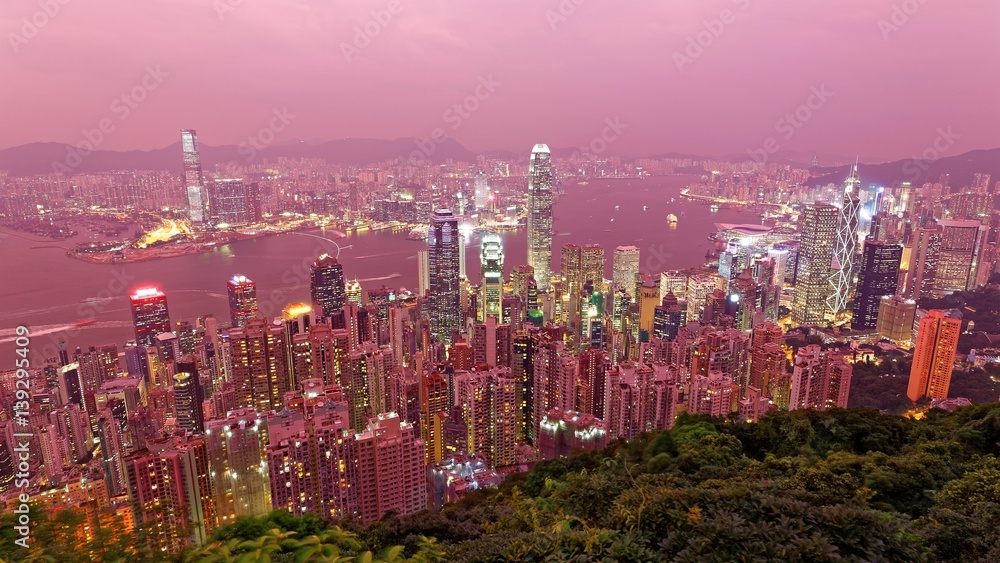 Obraz premium Hazy dusk scenery of Hong Kong viewed from Victoria Peak with city skyline of crowded skyscrapers by Victoria Harbour and Kowloon area ~ with air pollution level classified as 