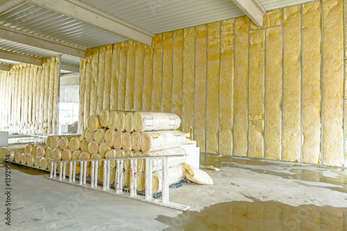 Package of thermal insulation material, rock wool is wrapped in foil. Used wooden ladder photo