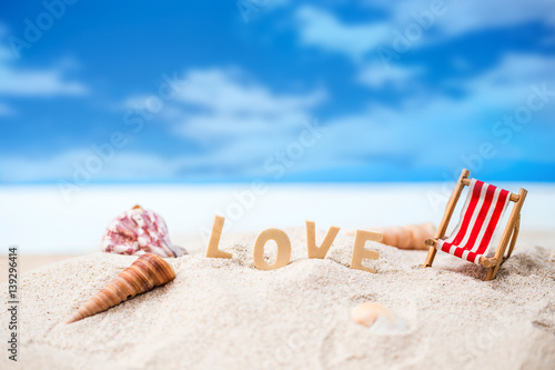 valentine decoration with love wooden text and beach chair on white sand beach with tropical blue sea and clear blue sky,Image For Love Valentine Day or summer   vacation Concept.