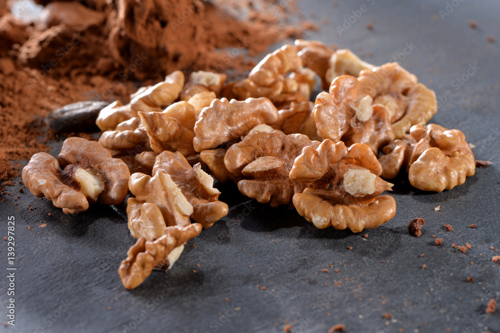 peeled walnuts kernels with cacao powder close-up on black slate plate
peeled walnuts kernels with cacao powder close-up on black slate plate