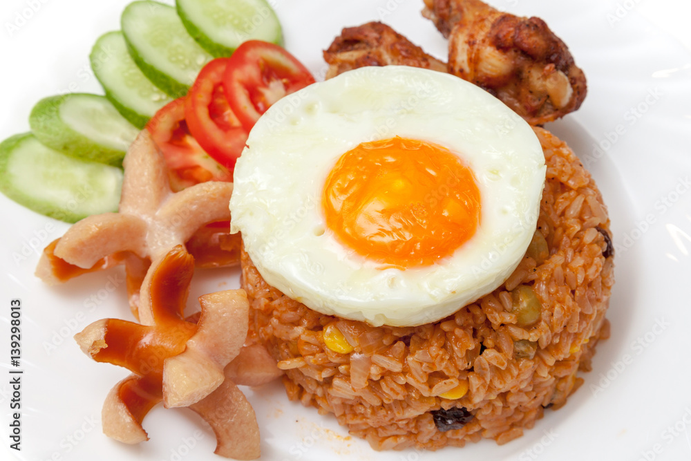 American fried rice with sausages, fried egg, fried chicken, cucumber and tomatoes,Thai style