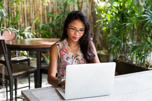 Young adult girl working on laptop in casual attire 