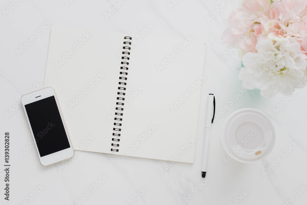Note book,smartphone,coffee cup and flower on white marble table background. Note book,smartphone,coffee cup and flower on white marble table background.