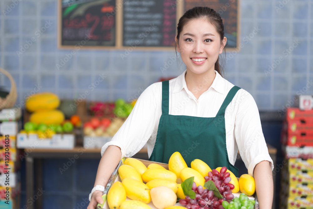 Obraz premium young pretty woman works in fruit store