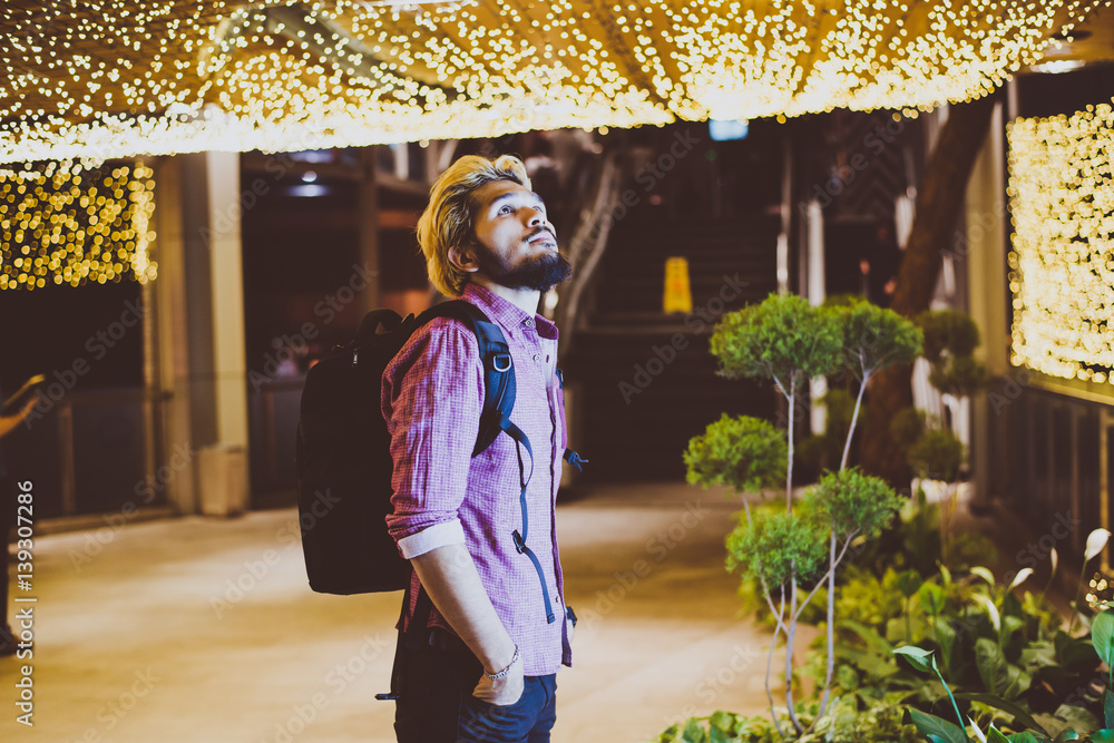 Handsome bearded man with backpack standing on the street while traveling at night. Handsome bearded man with backpack standing on the street while traveling at night.