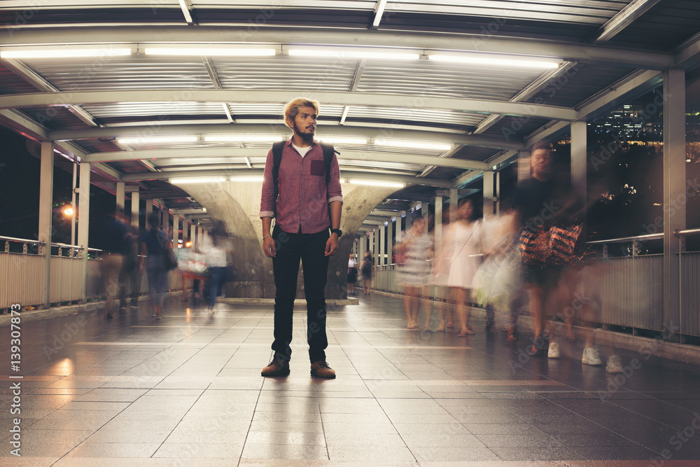 Obraz premium Handsome bearded man with backpack standing on the street traveling at night.