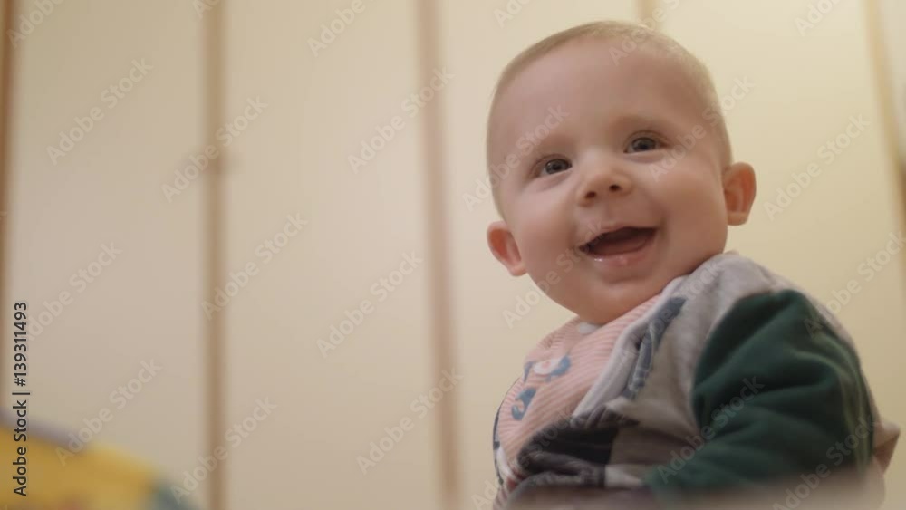 A cute little boy is looking into the camera and smiling