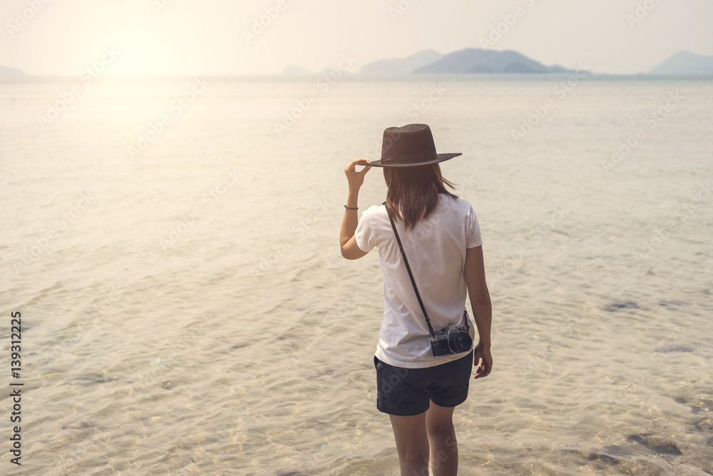 Young woman traveller with retro camera on the beach Young woman traveller with retro camera on the beach