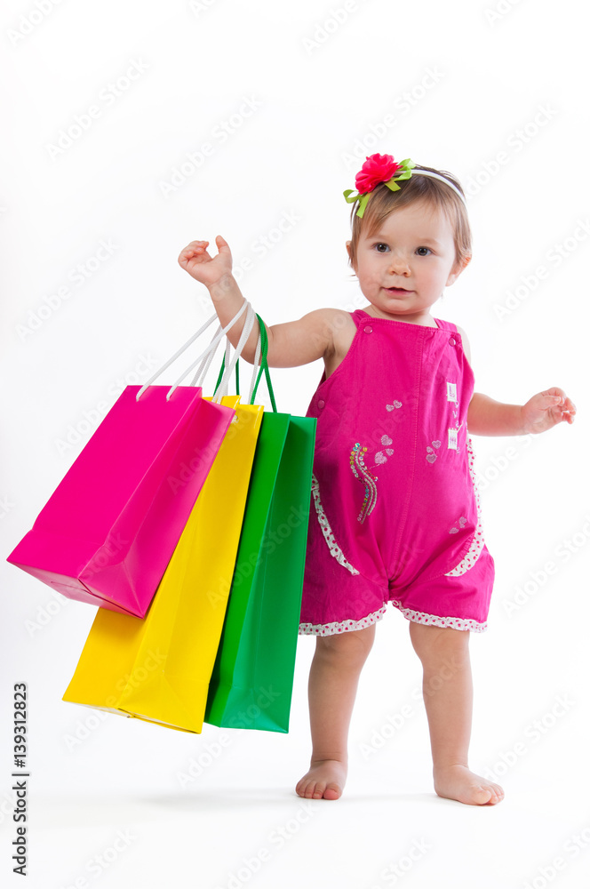 Little girl is surprised with colorful paper bags isolated on white background. Little girl is surprised with colorful paper bags isolated on white background.