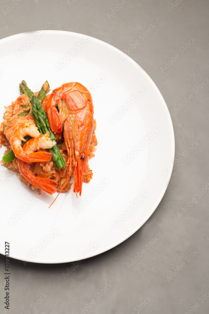 rice in tomato sauce with shrimp, cauliflower and asparagus on a white plate top view. rice in tomato sauce with shrimp, cauliflower and asparagus on a white plate top view.