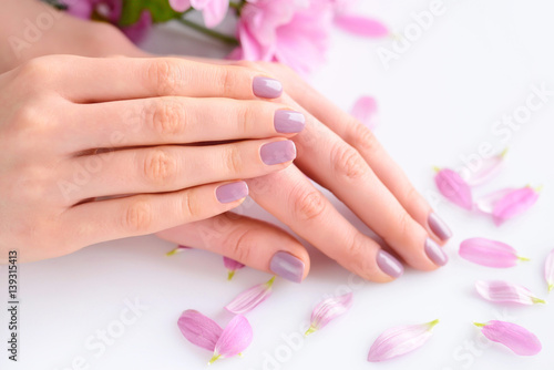Closeup of hands of a young woman with pink manicure on nails