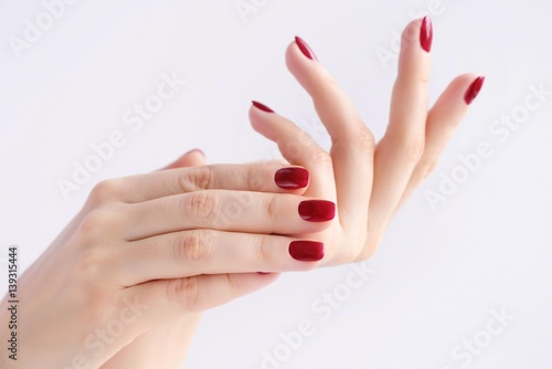 Closeup of hands of a young woman with red manicure on nails