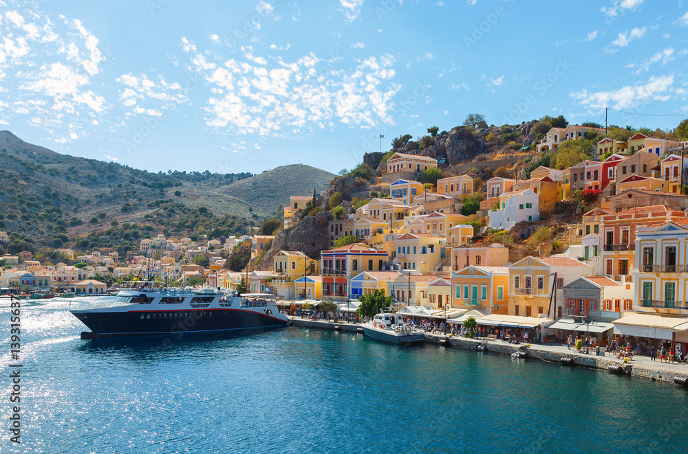 Bay of Symi, with ships and rich blue sky with clouds