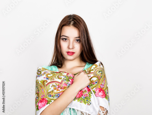beautiful young woman dressed in a red dress and colored scarf posing in studio