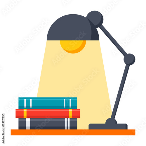Stack of books and lamp on table