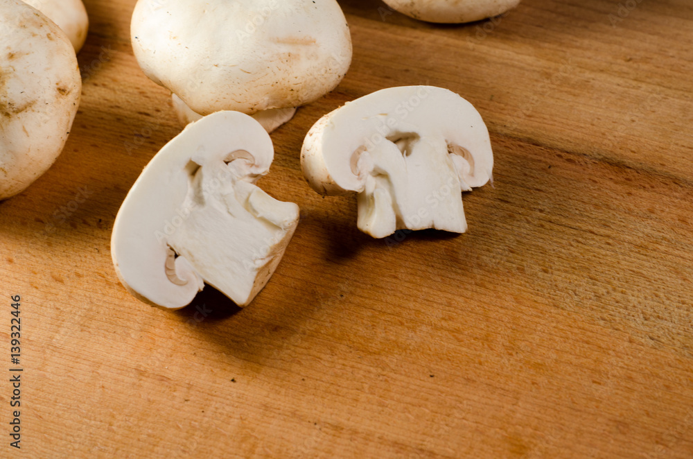 White champignon mushrooms on a wooden table White champignon mushrooms on a wooden table