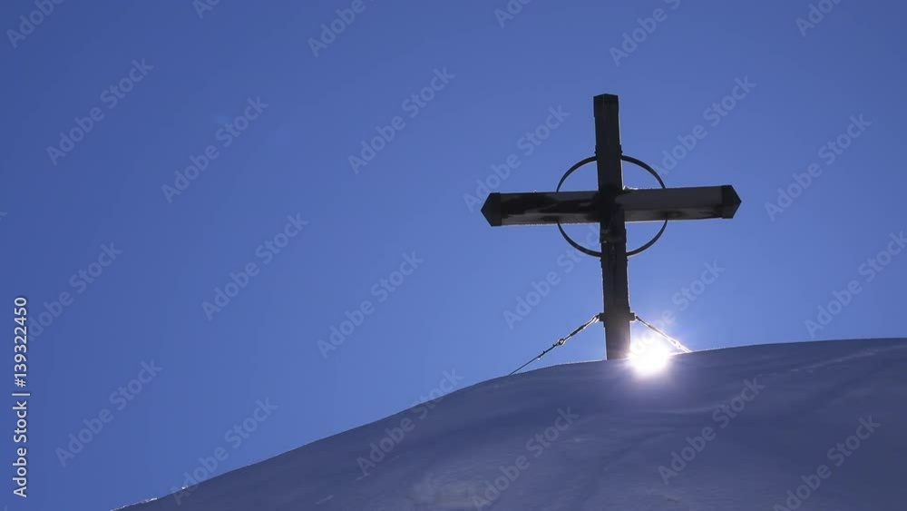 Wooden cross on top of snow covered hill, time lapse footage of setting sun Wooden cross on top of snow covered hill, time lapse footage of setting sun