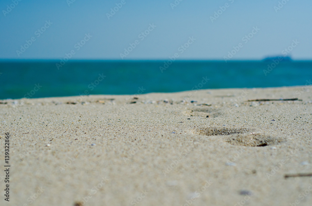 Footprints on the sandy coast and soft, blue background Footprints on the sandy coast and soft, blue background