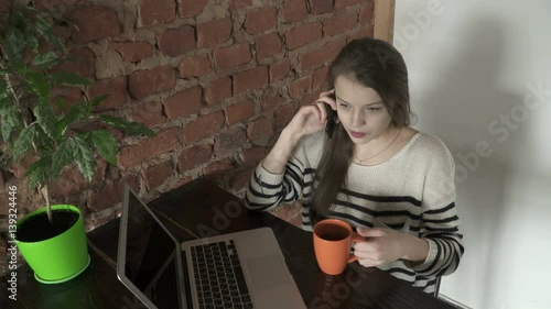 Top view of teenager girl sitting and talking on the phone photo