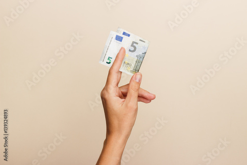 Woman's hand with money on a light background