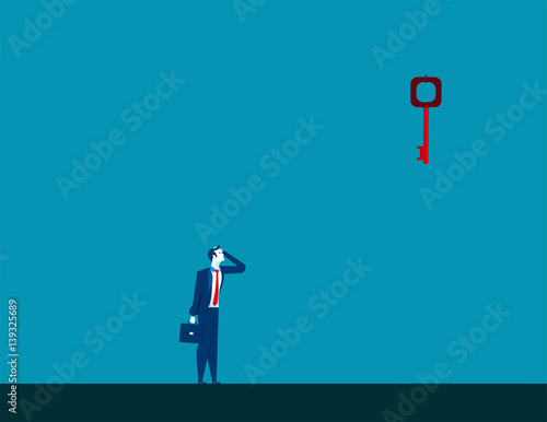 Businessman looking up at key high up in wall