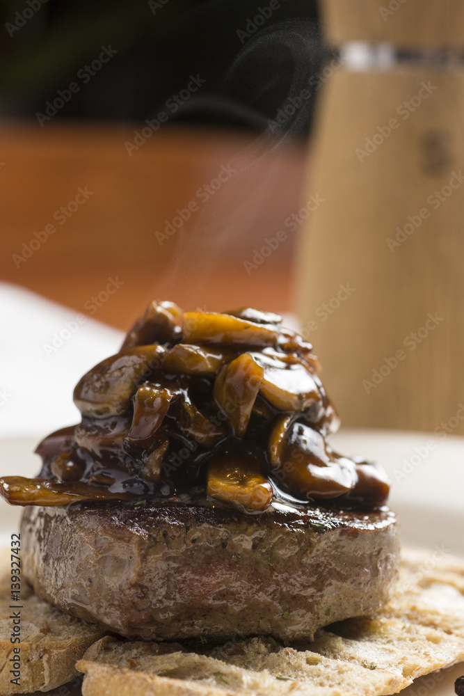 Beef Steak Fillet Covered with Mushroom Sauce on Toasted Baguette Bread with Melting Butter and Herbs