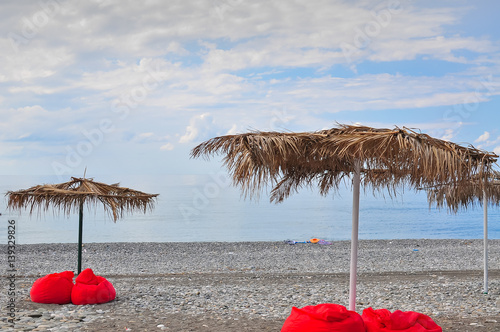 Tropical beach in sunset with beach chairs and umbrella photo