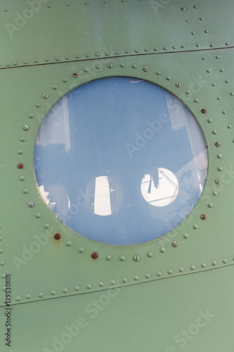 Bild auf Leinwand Window in old airplane, aluminum background detail of a military aircraft