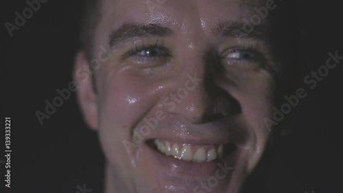 Intense sweaty face of young muscular man pulling rope photo