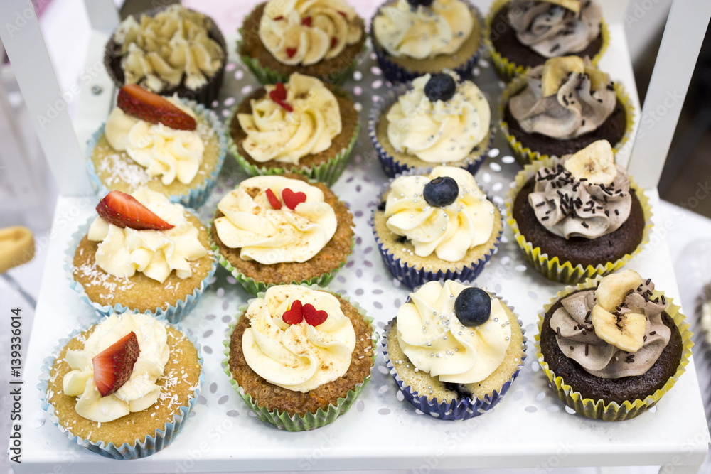 Delicious cupcakes with buttercream and fruits Delicious cupcakes with buttercream and fruits