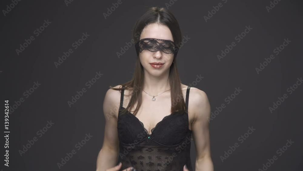 Sexy brunette woman in black underwear and headband touching herself, gray background Sexy brunette woman in black underwear and headband touching herself, gray background