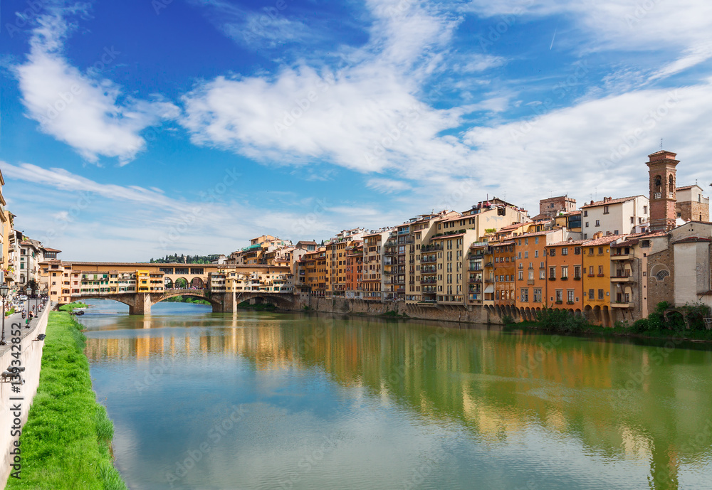 Ponte Santa Trinita bridge and Ponte Vecchio bridge with medieval houses over the water of Arno River, Florence, Italy