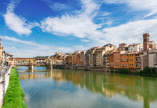 Ponte Santa Trinita bridge and Ponte Vecchio bridge with medieval houses over the water of Arno River, Florence, Italy
