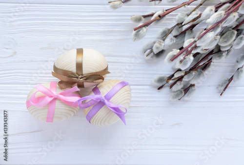 Wooden eggs with colorful tapes with twig of pussy willow on white backround photo