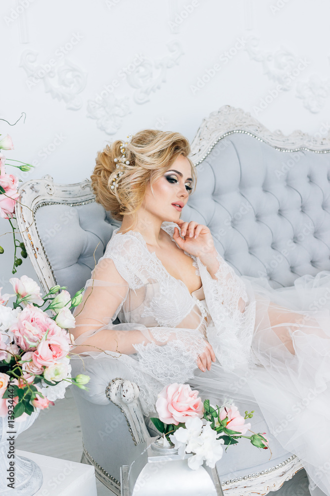 Bride in a peignoir/Young, beautiful girl sits on a sofa in a white negligee Bride in a peignoir/Young, beautiful girl sits on a sofa in a white negligee
